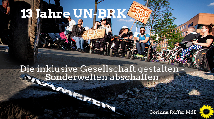 Bild einer Demonstration mit u.a. Rollifahrern. Darauf steht der Text: "13 Jahre UN-BRK: Die inklusive Gesellschaft gestalten - Sonderwelten abschaffen