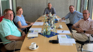 Zu sehen ist ein ovaler Tisch, um den von links nach rechts sitzen: Richard Leuckefeld (Grüne Stadtratsfraktion Trier), Corinna Rüffer (MdB), Alfred Wirtz (Bürgermeister Ralingen), Dr. Matthias Schwalbach (HWK Trier) und Dr. Matthias Schmitt (IHK Trier).