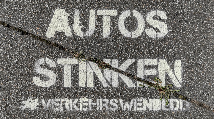 Asphalt, auf dem in weißer Farbe steht: Autos stinken - #Verkehrswende